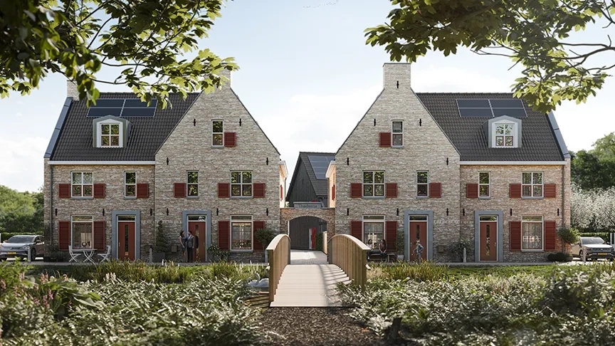 Groenstrook met brug die leidt naar de tweekappers