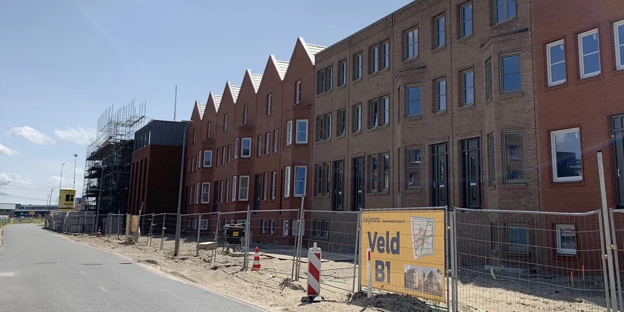 Rijwoningen met erker in aanbouw met bouwhek ervoor