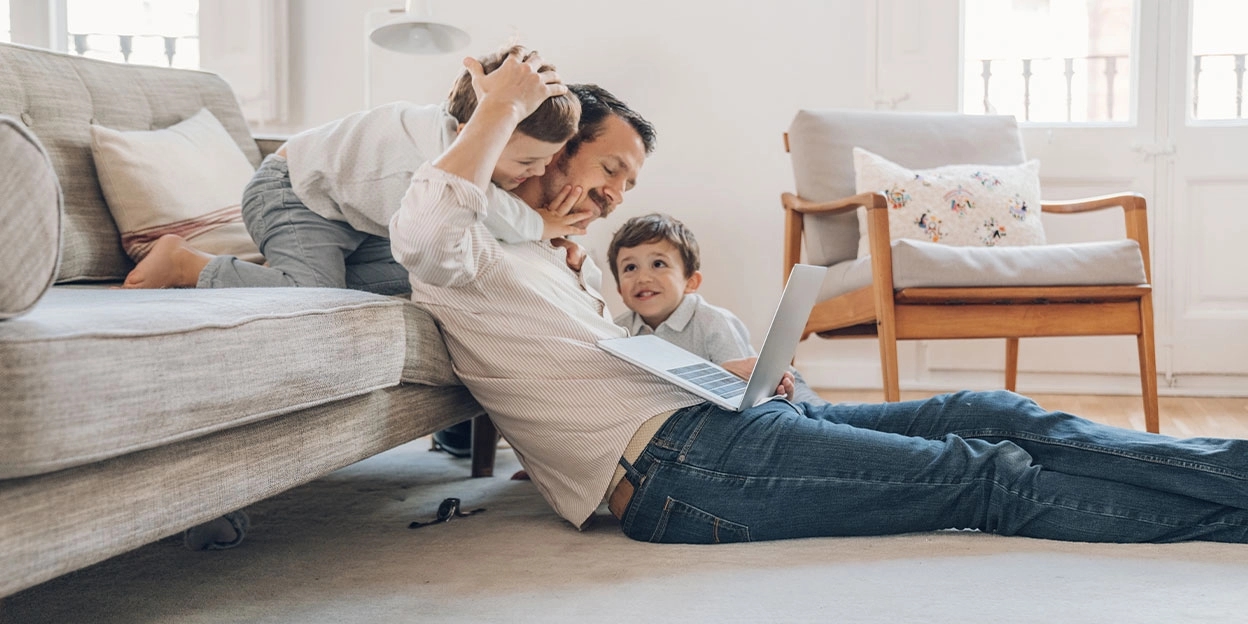 Vader probeert te werken met twee jonge kinderen die aandacht willen