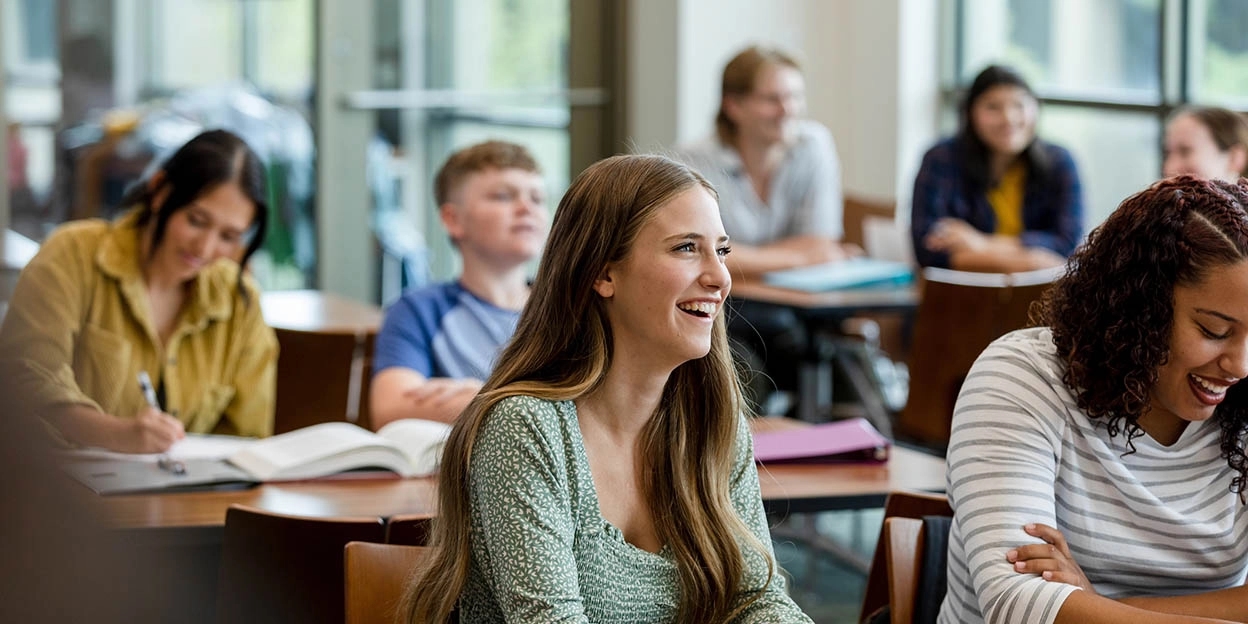 Student lacht tijdens het hoorcollege van haar studie