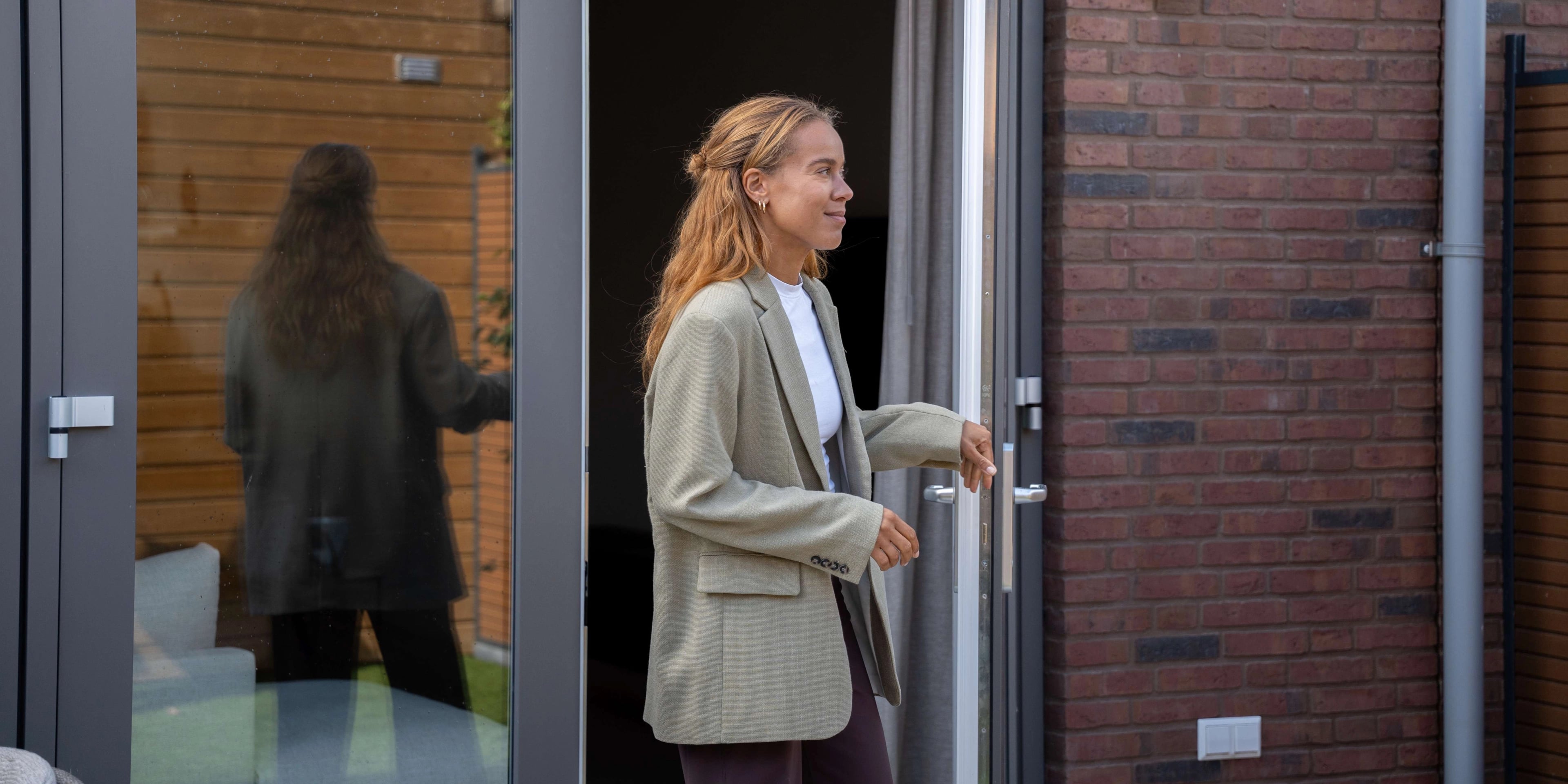 Vrouw stapt haar tuin in vanuit de woonkamer
