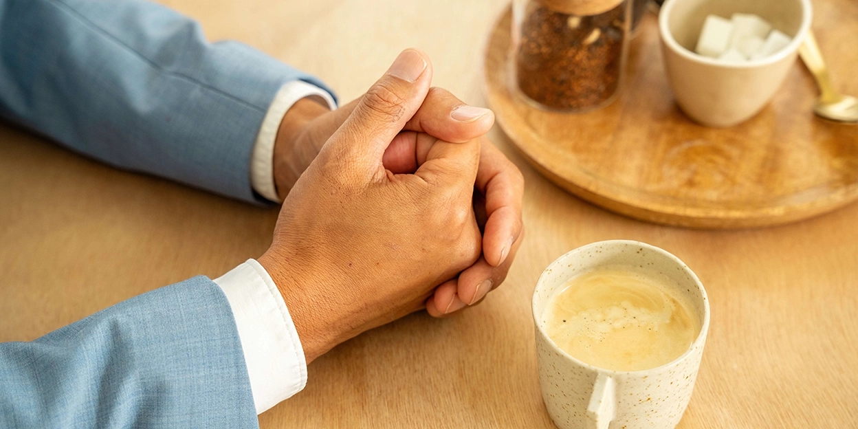 Man legt zijn handen op tafel voor een gesprek