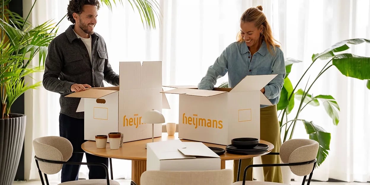 Man en vrouw pakken op tafel hun verhuisdozen in