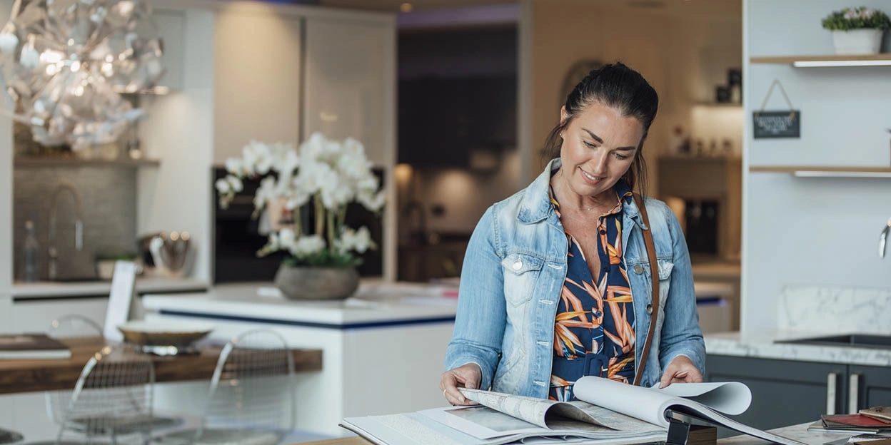 Vrouw bladert door brochures in een keukenshowroom