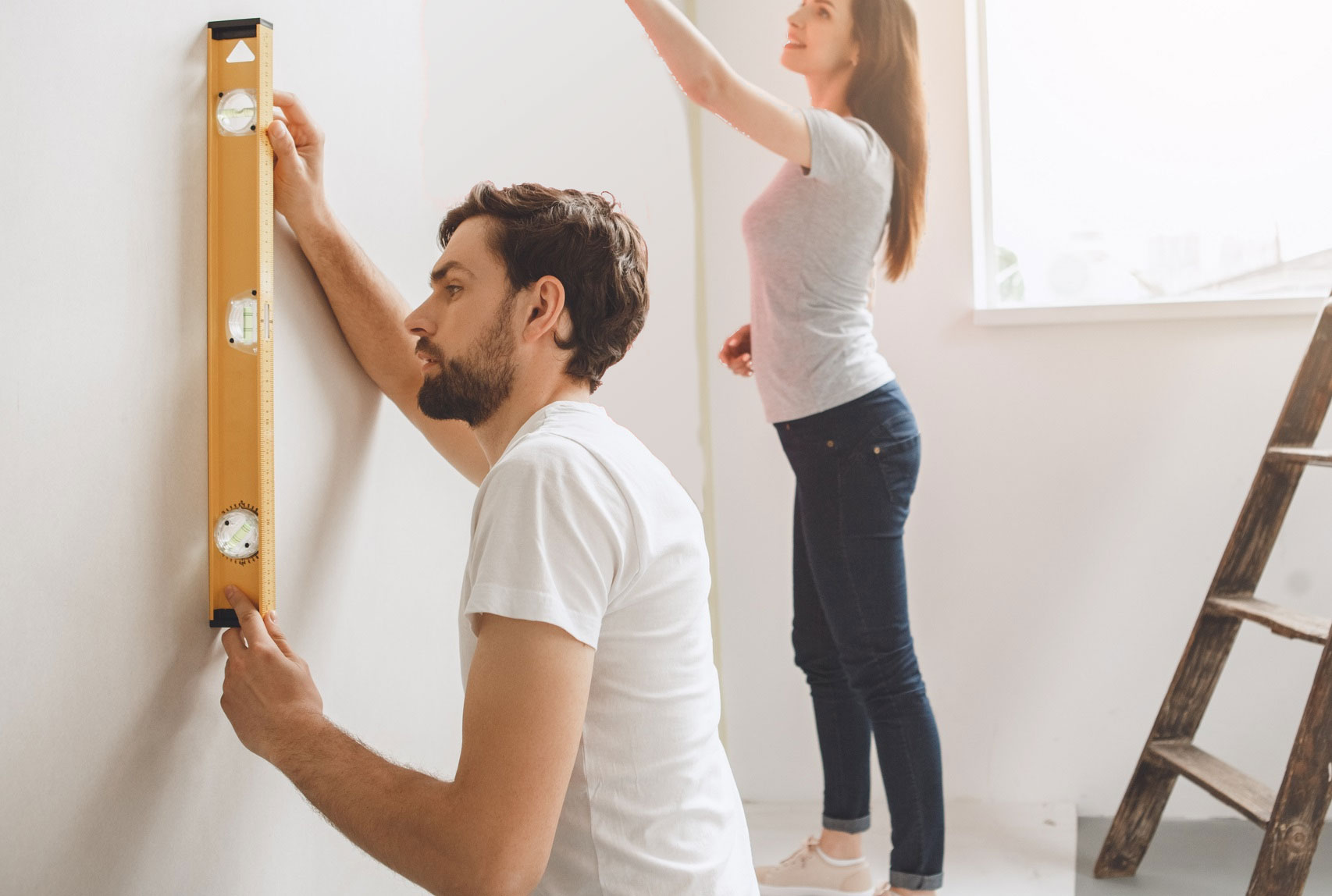 Man en vrouw zijn samen aan het behangen